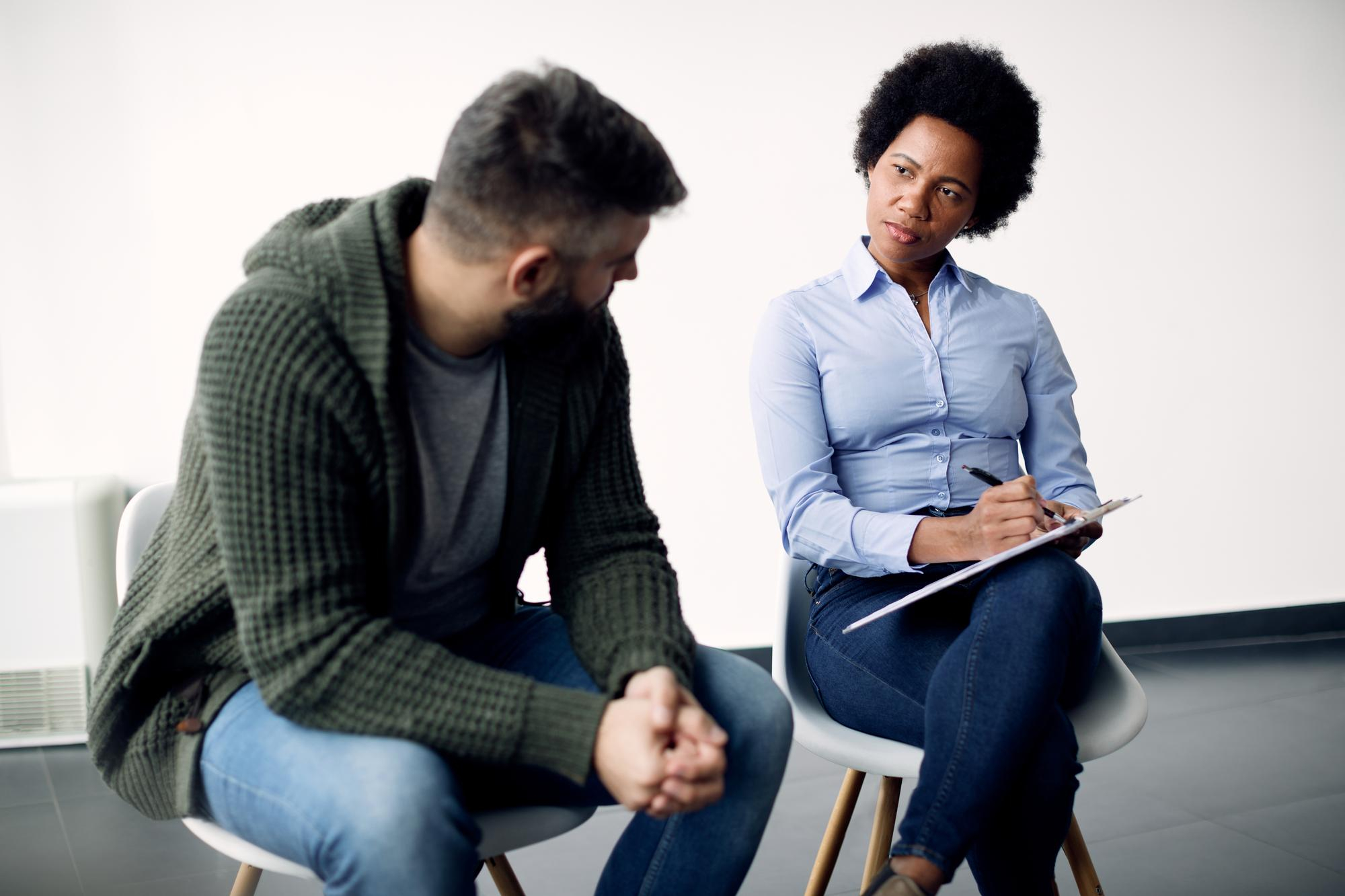Social counselling support worker with a man listening attentively.